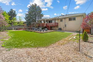 Back of property featuring a deck, brick siding, a fenced backyard, and a patio