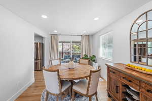 Dining area with light wood finished floors and recessed lighting