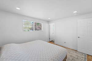 Bedroom with light wood-style floors and recessed lighting
