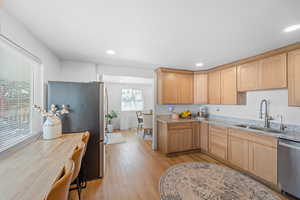 Kitchen with stainless steel appliances, light wood finish cabinetry, light stone countertops, light wood-style floors, and recessed lighting