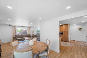 Dining area with light wood-style floors and recessed lighting