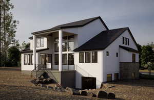 Back of property featuring roof with shingles and stucco siding