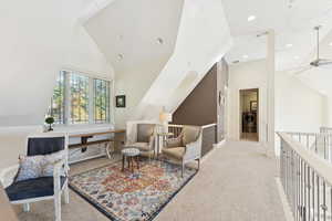 Living area with lofted ceiling, light carpet, a ceiling fan, and recessed lighting