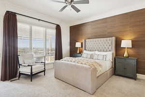 Bedroom featuring light colored carpet, a ceiling fan, and crown molding