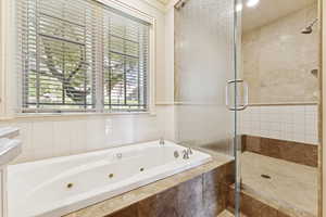Bathroom with a stall shower, a whirlpool tub, and recessed lighting