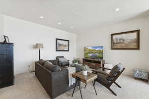 Living area with light carpet, a textured ceiling, and recessed lighting