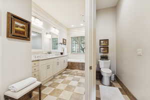 Full bathroom with double vanity, a garden tub, and recessed lighting