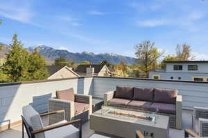 View of patio / terrace featuring an outdoor living space with a fire pit, a mountain view, and a residential view