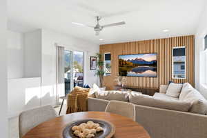 Carpeted living room with an accent wall, ceiling fan, wallpapered walls, and recessed lighting
