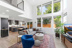 Living area featuring a high ceiling, light wood finished floors, and recessed lighting