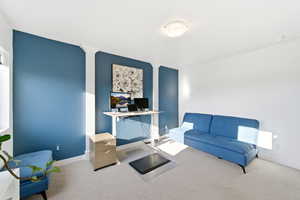 Sitting room with carpet floors and an office area