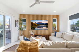 Living area featuring an accent wall, healthy amount of natural light, a ceiling fan, and recessed lighting