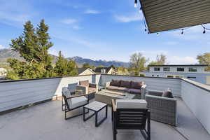 View of patio with a mountain view and an outdoor living space with a fire pit