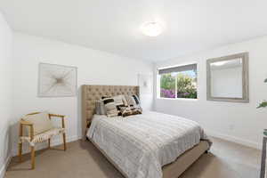 Bedroom featuring light carpet and baseboards