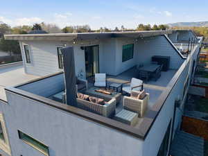 Rear view of property featuring a fire pit, a mountain view, and a patio area