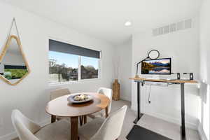Dining space with light colored carpet and recessed lighting