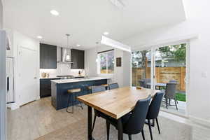 Dining area with light wood-style floors and recessed lighting