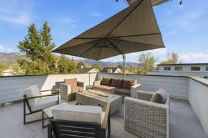 View of patio featuring a mountain view and an outdoor living space with a fire pit
