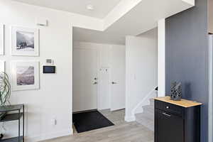 Entryway with light wood-style floors and stairway