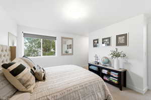 Bedroom with light carpet and baseboards