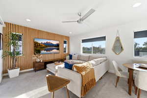 Living area featuring light carpet, ceiling fan, recessed lighting, an accent wall, and wallpapered walls