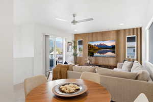 Carpeted dining area featuring a ceiling fan, recessed lighting, and an accent wall