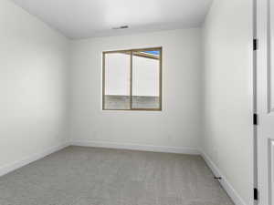 Spare room with light colored carpet and baseboards