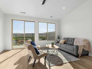 Living area featuring lofted ceiling, light wood finished floors, and recessed lighting