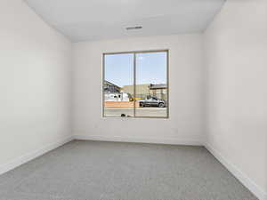 Empty room featuring light carpet and baseboards