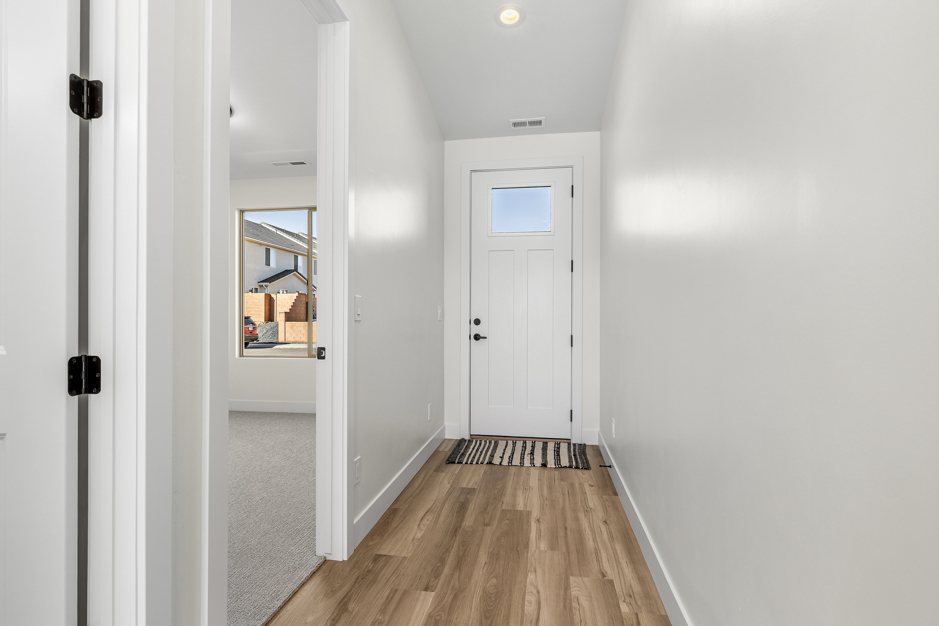 Entryway with wood finished floors and recessed lighting