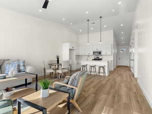 Living area with light wood finished floors, recessed lighting, and lofted ceiling