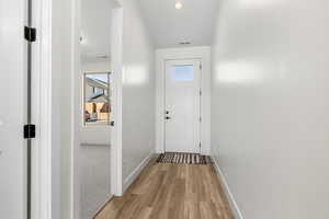 Entryway with wood finished floors and recessed lighting