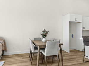 Dining space featuring light wood-style floors and baseboards
