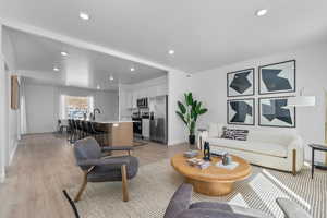 Living room with light wood finished floors and recessed lighting