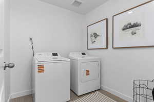 Laundry area featuring separate washer and dryer and light wood finished floors