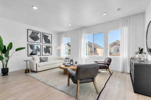 Living room featuring light wood finished floors and recessed lighting