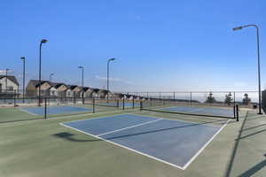 View of tennis court with a residential view