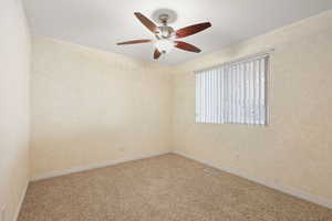 Spare room with carpet and ceiling fan