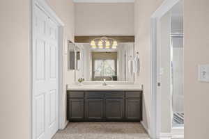 Bathroom with vanity, light carpet, and a shower stall