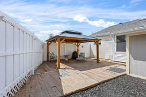Wooden deck featuring a gazebo, and a fenced backyard.