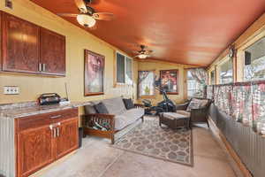 Sunroom / solarium featuring concrete floors, and a vaulted ceiling