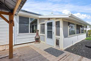 Backyard entrance to property featuring roof mounted solar panels and a deck