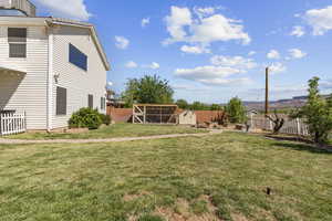 Fenced backyard featuring a shed