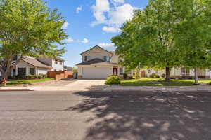 View of front of home with a residential view, stone siding, concrete driveway, and a garage
