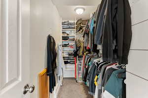 Walk in closet featuring light carpet