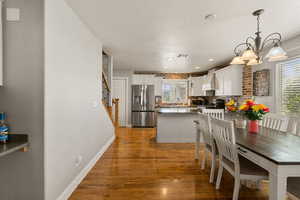 Dining space featuring light wood-type flooring, suspended lighting, and plenty of natural light