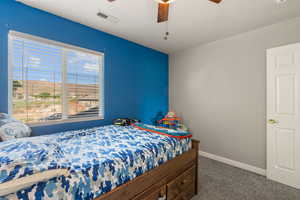 Bedroom featuring dark colored carpet and a ceiling fan
