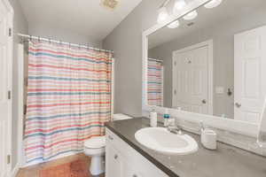 Bathroom with vanity, curtained shower, and light tile patterned flooring