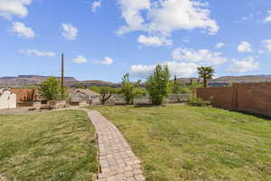 Fenced backyard featuring a mountain view and a patio area