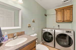 Laundry area with washer and dryer and a textured wall